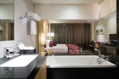 莱卡邦Amaranth Suvarnabhumi Hotel的一间带大水槽和床的浴室