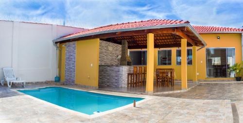 圣若昂-巴蒂斯塔-杜格罗里亚Pouso Oliveira Casa com ar condicionado的一座带游泳池和房子的别墅