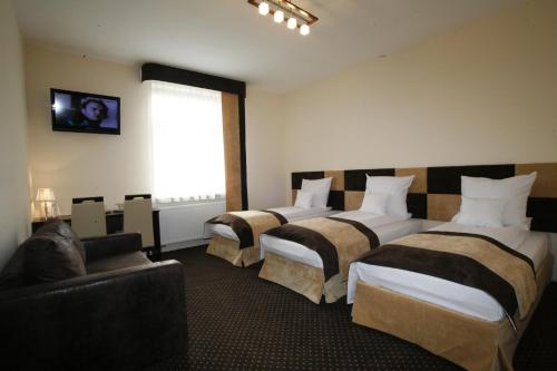 罗兹一号精品酒店的酒店客房,设有三张床和一张沙发