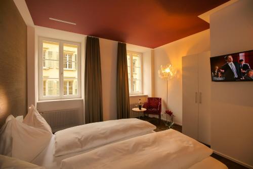 布格多夫Boutique Hotel - Restaurant Orchidee的一间卧室配有两张白色的床和电视