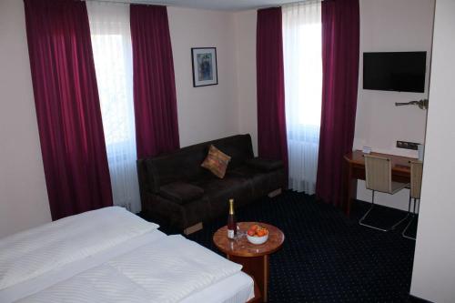 陶贝尔比绍夫斯海姆阿德勒霍夫酒店的配有一张床和一把椅子的酒店客房