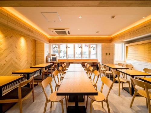 高松Super Hotel Takamatsu Kin en kan的用餐室配有木桌和椅子