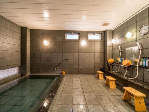 高松Super Hotel Takamatsu Kin en kan的浴室设有游泳池、长椅和水槽