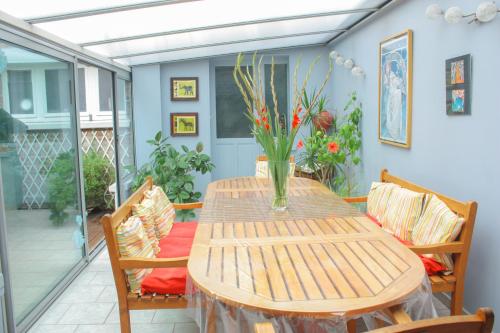 里尔梅特姆科莱住宿加早餐旅馆的庭院里摆放着一张带椅子的木桌和花瓶