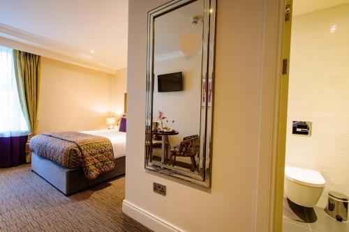 特拉利特拉利大酒店的酒店客房,配有床和镜子