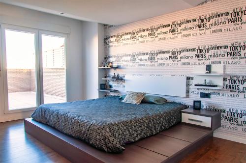 贝尼卡洛Atic luxe Benicarló的一间卧室配有床,墙上写着书