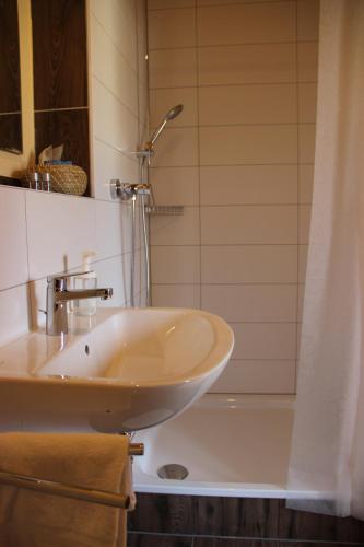 格平根Friederike Wackler Gästehaus的浴室配有盥洗盆和浴缸。