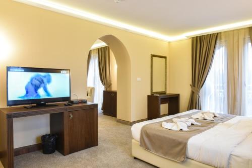 斯维伦格勒Sahara Hotel的配有一张床和一台平面电视的酒店客房
