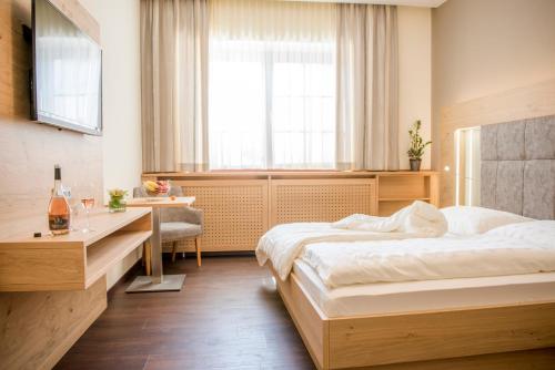 雷茨Weingut Breitenfelder的一间卧室设有两张床、一张桌子和一个窗口。