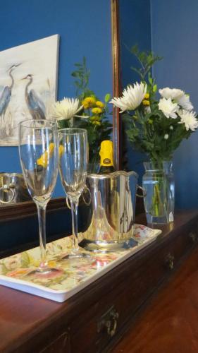 约尔Abbey View House的鲜花桌子上装有酒杯的托盘