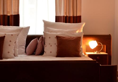 克拉科夫Castle View Boutique Apartment的一张带枕头的床和一张桌子上的灯