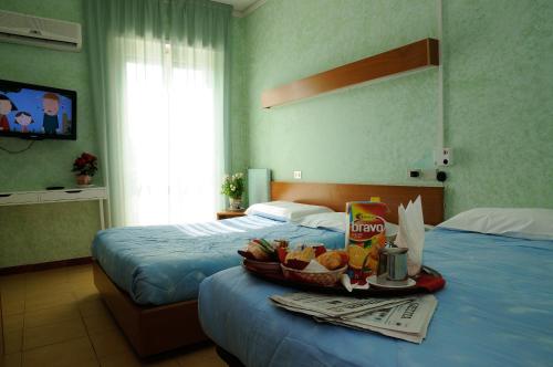 瓦拉泽潘塔贝拉酒店的一间酒店客房,配有两张床和一张桌子上的盘子