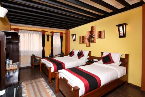 加德满都卡玛精品酒店的黄色墙壁客房的两张床