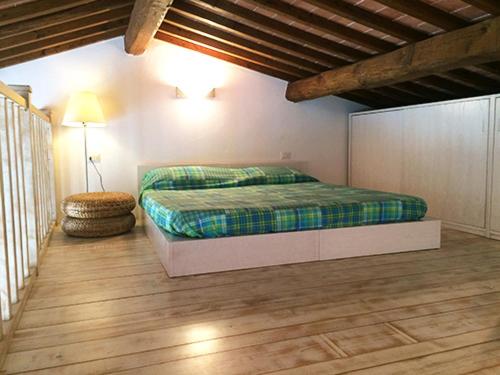 坎波内莱尔巴Appartamento elegante a Marina di Campo的一间卧室配有一张床,铺有木地板