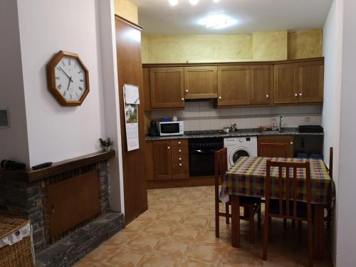 RoníApartament de la Lali Roní的厨房配有桌子和墙上的时钟