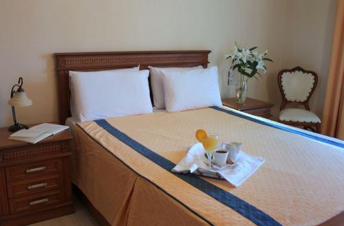 卡兰巴卡Famissi Hotel的一张带盘子的床上,上面有杯子和玩具