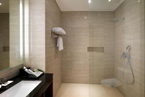 当格浪Swiss-Belhotel Airport Jakarta的带淋浴、盥洗盆和浴缸的浴室