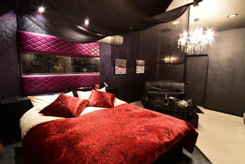 宇都宫Restay Koakuma (Adult Only)的一间卧室配有一张红色的床和吊灯。