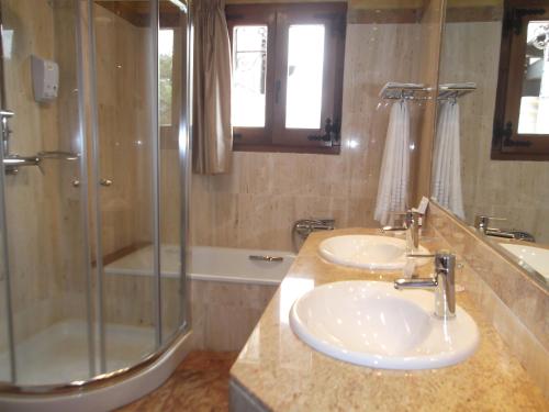 拉阿贝尔卡圣堂修道院温泉酒店的一间带两个盥洗盆和淋浴的浴室
