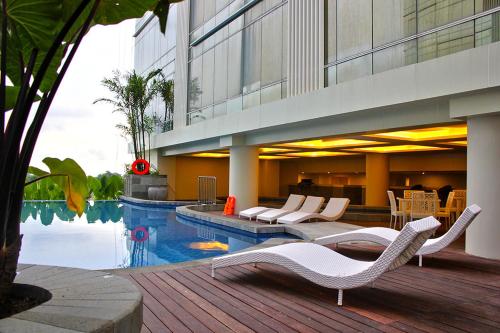 日惹Lavenderbnb Room 5 at Mataram City的一座带游泳池和椅子的酒店和一座建筑