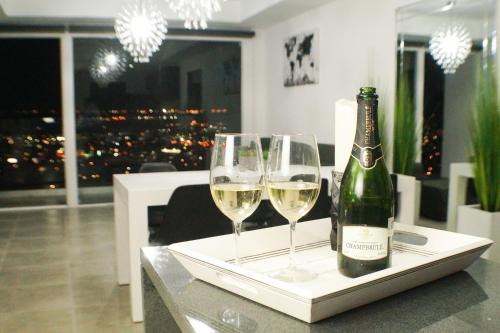 提华纳Luxurious Condo & unparalleled Comfort inTijuana的桌子上放有一瓶葡萄酒和两杯酒