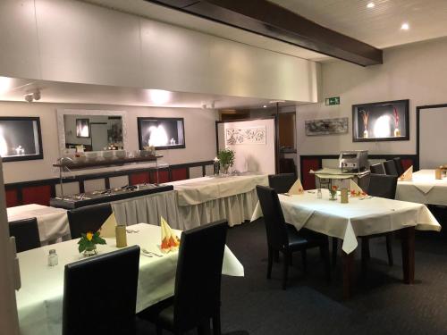 沃尔夫斯堡Hotel & Restaurant Blume的餐厅配有桌椅和白色桌布