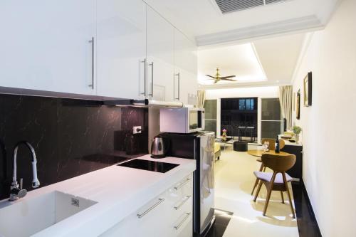 芭堤雅市中心Beautiful Apartment D6 Central Pattaya的厨房配有白色橱柜和黑白电器