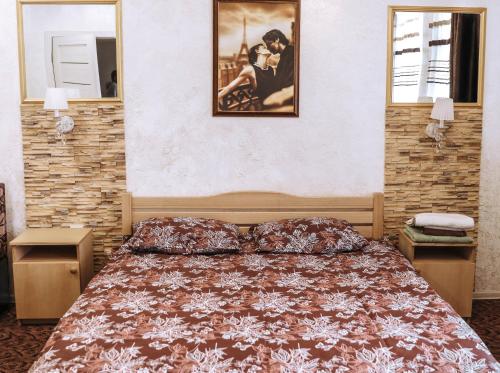 利沃夫Hotel Rafinad的卧室配有一张床,墙上挂着一幅画