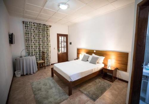 圣多美Praia Accommodation的一间卧室配有一张床和一张桌子