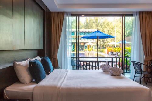 七岩七岩阳光码头酒店的一间卧室配有一张床,阳台配有遮阳伞
