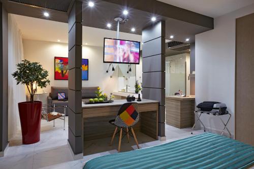 尼亚·蒙达尼亚索克拉提斯酒店的一间卧室配有书桌,另一间卧室配有电视。