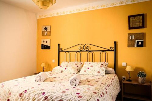 Torremocha del CampoCasa Rural La Alegría de la Alcarria III的卧室内的一张床位,卧室拥有黄色的墙壁
