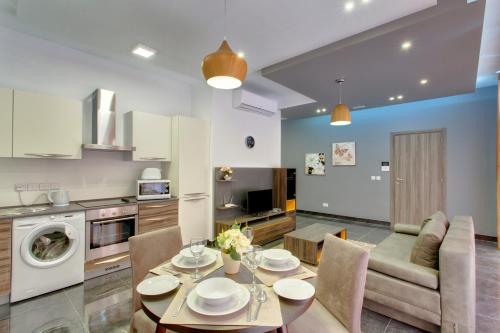 斯利马Chalet Apartments的厨房以及带桌椅的起居室。