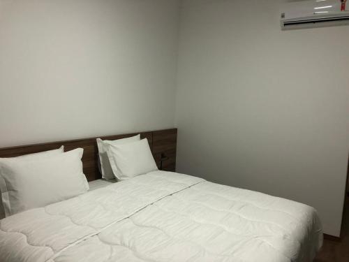 阿普卡拉纳Hotel Matrix的一张带白色床单和枕头的床
