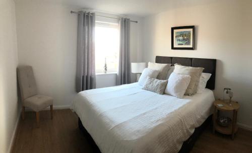 卡迪夫Hansen House Cardiff Apartment with Parking的卧室配有一张大白色床和窗户