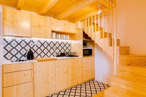 法鲁A Casa D'Amelie的一间带木制橱柜和楼梯的厨房