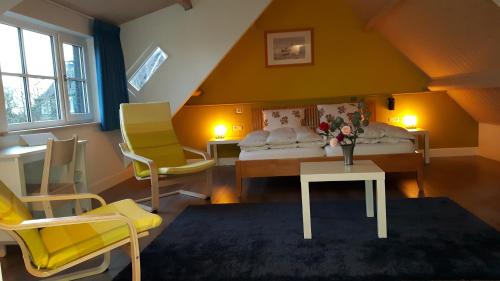 马斯丹B&B de Oude Hofstee的一间卧室配有一张床和两张黄色椅子