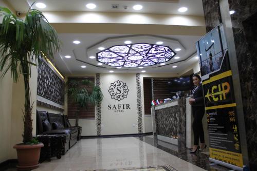 杜尚别SAFIR BUSINESS HOTEL o的站在沙龙柜台的女人