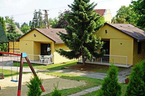 鲍洛通塞派兹德木兰酒店的黄色的房子,前面有一个游乐场