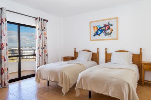 波尔蒂芒Mirachoro Praia da Rocha的带窗户的客房内的两张床