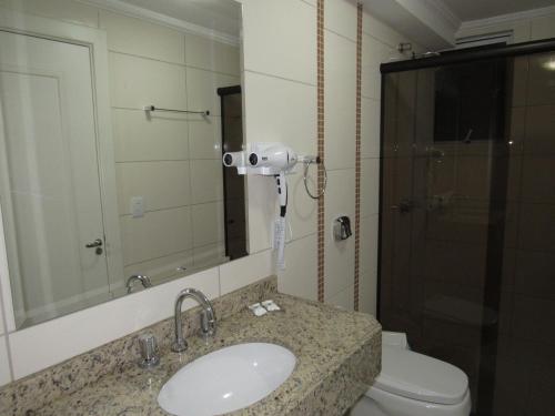 拉热阿杜HOTEL MARIANI的一间带水槽、卫生间和镜子的浴室