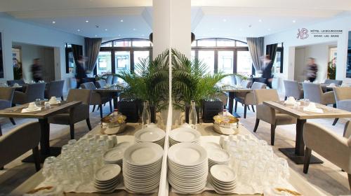 埃维昂莱班布尔格尼酒店的餐厅里一张桌子,上面有盘子和玻璃杯