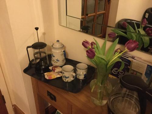 霍特惠斯尔The Snug @ Corry Cottage的一张桌子,上面放着花瓶和杯子
