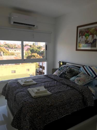 波萨达斯Departamento Rodrigo II的一间卧室配有一张床,上面有两条毛巾