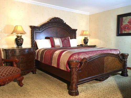 奥克港橡果汽车旅馆的一间卧室配有一张带两盏灯的大木床。