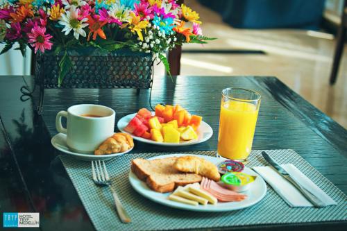 麦德林Tequendama Hotel Medellín - Estadio的一张桌子,上面放着两盘食物和一杯橙汁