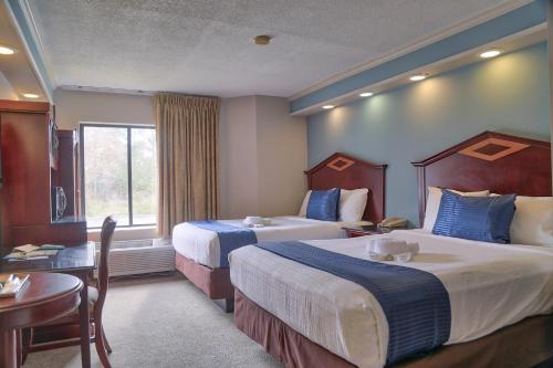 基西米麦格特韦斯特德斯蒂尼棕榈酒店的酒店客房设有两张床和一张桌子。