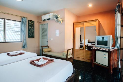 北碧贵族之夜宾馆的酒店客房设有两张床和电视。