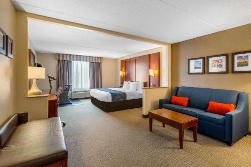 马纳萨斯马纳萨斯康福特套房酒店的酒店客房,配有床和蓝色的沙发