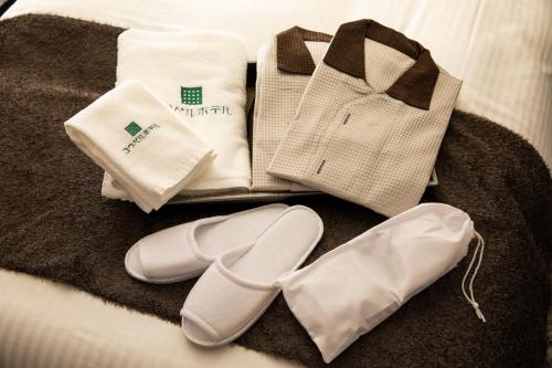 京都Kyoto Gion U-BELL Hotel的床上的一大堆毛巾和鞋子
